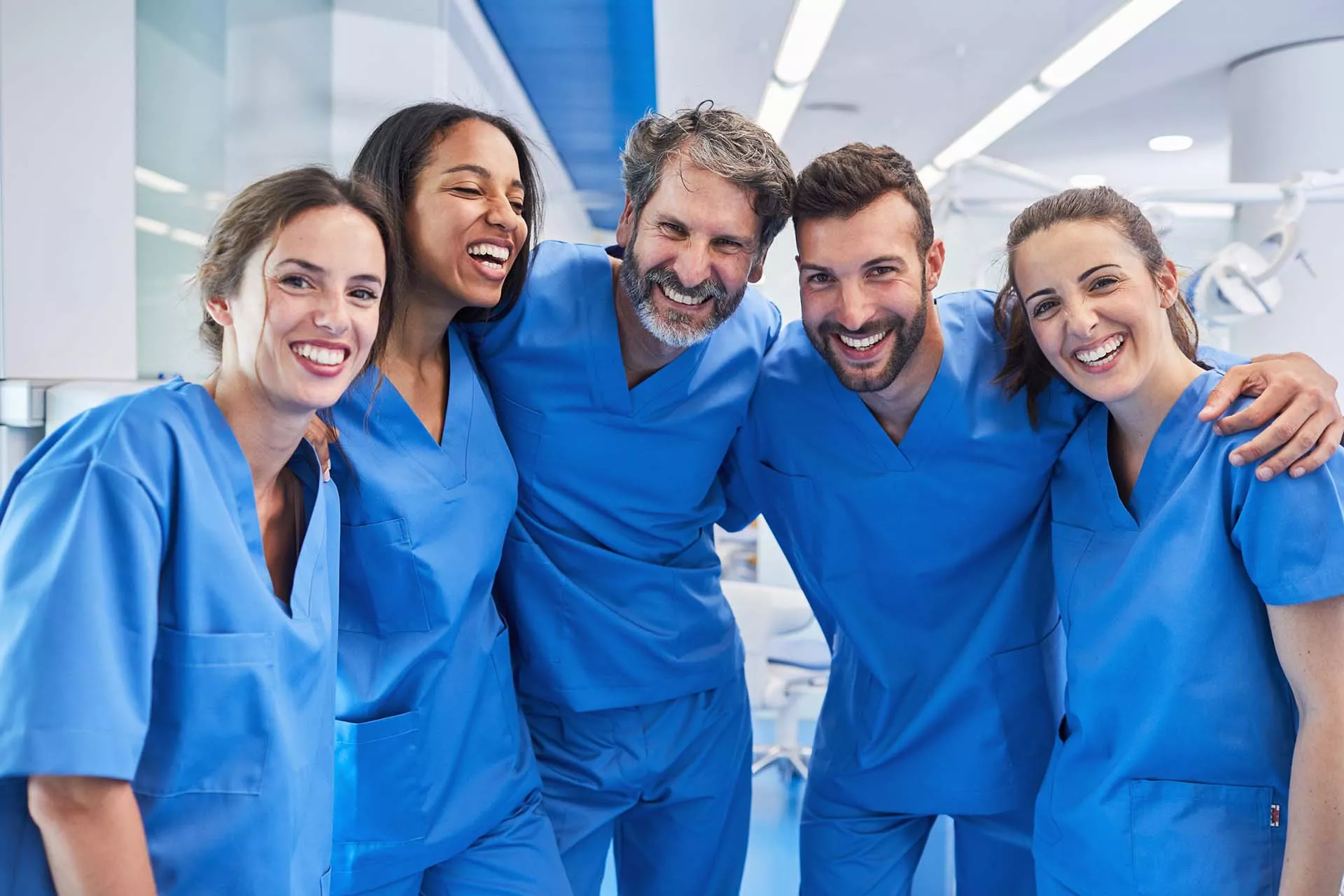 Gruppe mit lächelnden ilomed Pflegekräften bei einem Einsatz in der Klinik